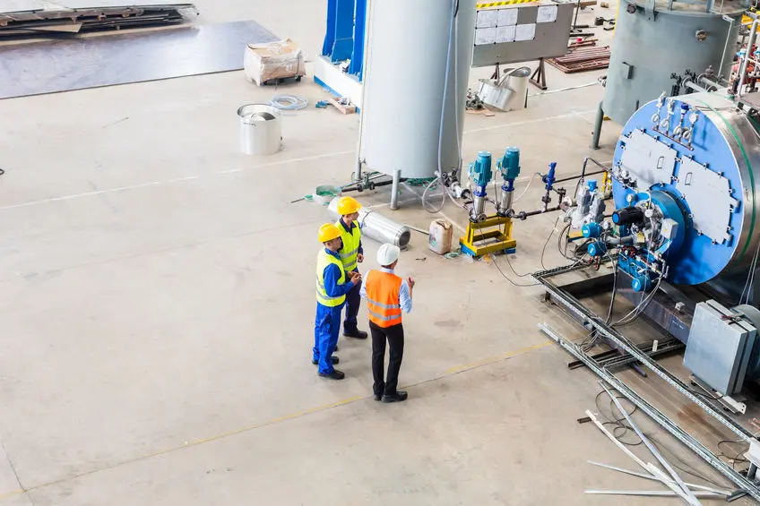 Worker and engineer discussing at machine